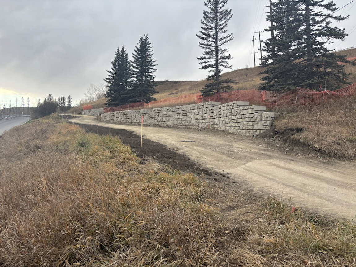 Photo of a pathway and retaining wall under construction along the hill from 50 Avenue SW to Sandy Beach Park